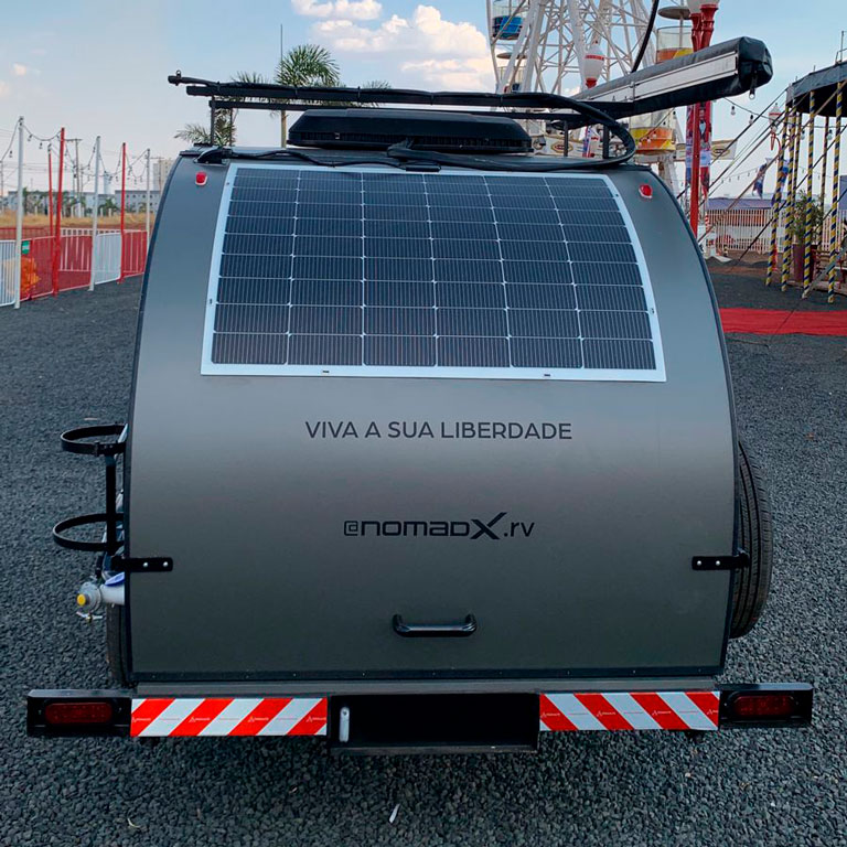 Mini trailer NomadX visto pela traseira, com placa solar instalada e slogan “Viva a sua liberdade”.